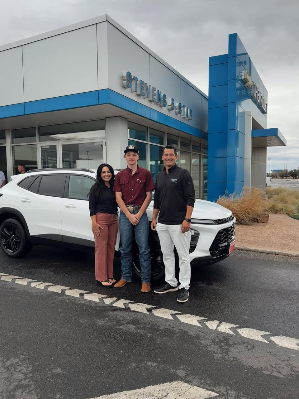 People celebrating beside a vehicle at Stevens 5-Star Car and Truck Center